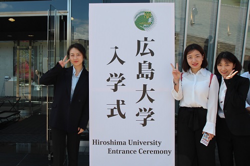 New students taking commemorative photos in front of the sign board