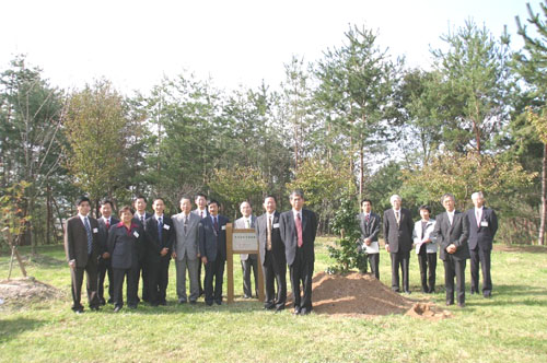 記念植樹を終え、関係者全員で記念写真。プレート右から文心田学長、高橋副学長