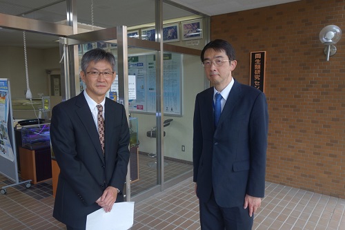 両生類研究センター前で荻野センター長の出迎えを受ける西井課長(右)