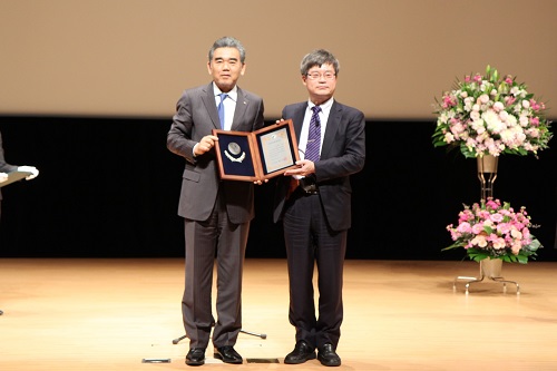 Professor Amano receiving the Commemorative Shield of the Honorary Distinguished Professor