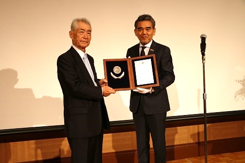 Professor Honjo receiving an award plaque for Honorary Professor of Hiroshima University from President Ochi