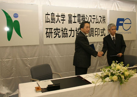調印を済ませ握手する岡田研究科長（左）と木田取締役（右）
