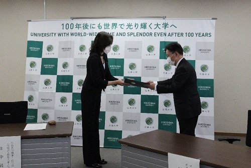 Executive Vice President Tanaka presenting a letter of appreciation to President Murata