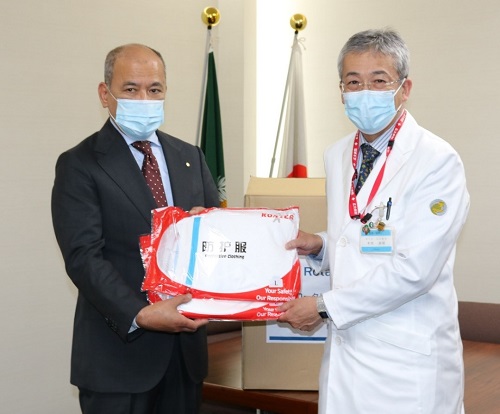 木内病院長(右)に防護服を手渡す広島西南ロータリークラブの山下会長 木内病院長(右)に防護服を手渡す広島西南ロータリークラブの山下会長