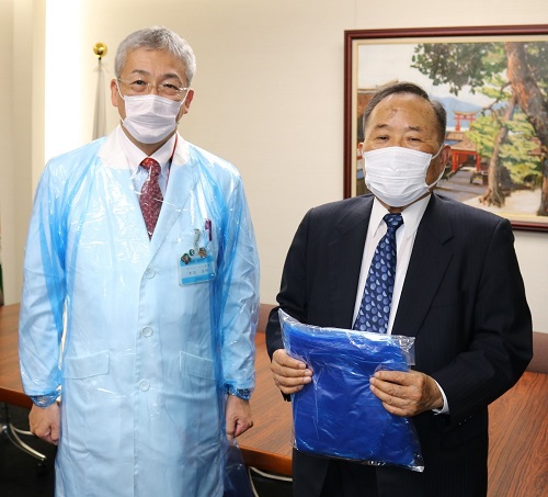 ビニールガウンを寄贈した大久保社長(右) ビニールガウンを寄贈した大久保社長(右)