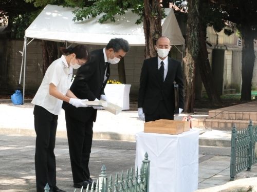 La representante de los familiares en duelo y el Presidente Ochi dedicando el registro al cenotafio.