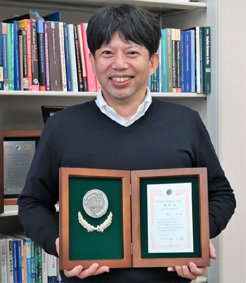 令和2年度「広島大学教育賞」 表彰盾を持つ榎田先生
