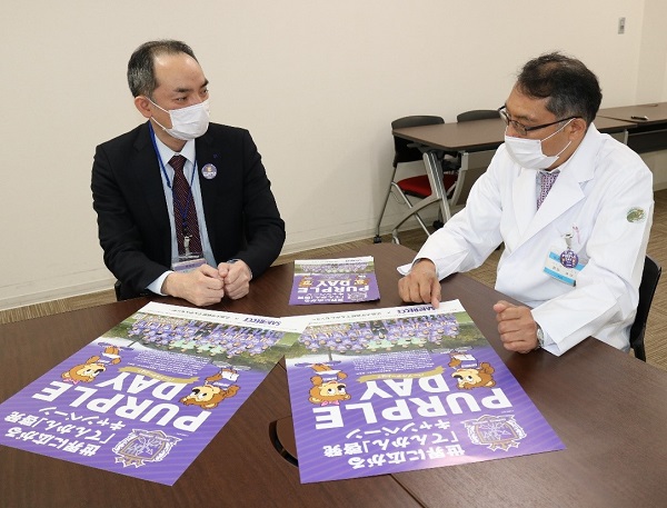 ポスターを見ながら話す松尾薬剤部長(左)と飯田てんかんセンター長 ポスターを見ながら話す松尾薬剤部長(左)と飯田てんかんセンター長