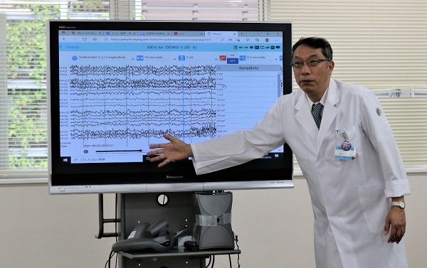 送られてきた脳波を解説する飯田センター長