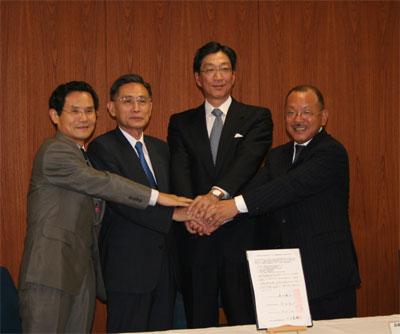 協定調印を終え握手する四者。左から茂里広島工業大学長、牟田広島大学長、藤田県知事、川本広島県産業廃棄物協会会長