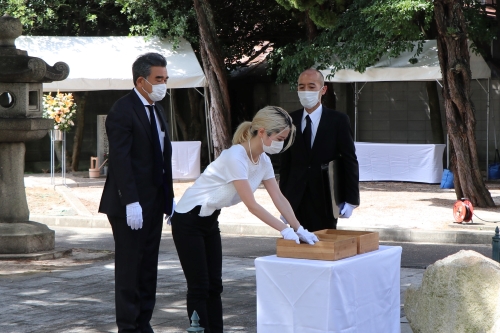 La representante de los familiares en duelo y el Presidente Ochi dedicando el registro al cenotafio. 
