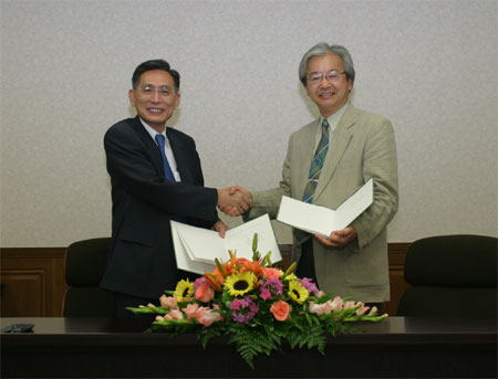 調印を済ませ握手する牟田学長（左）と海部台長（右）