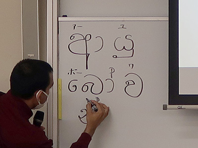 シンハラ語で「こんにちは」と書くダンマシリさん シンハラ語で「こんにちは」と書くダンマシリさん