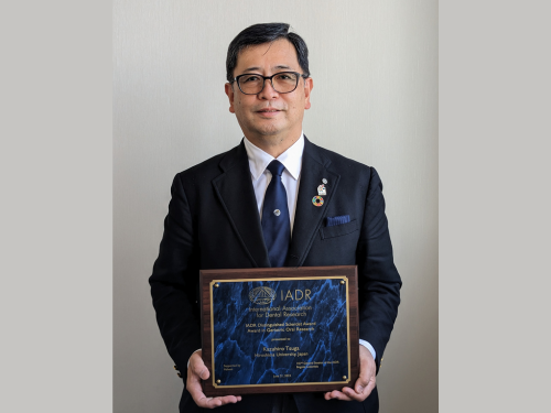 Hiroshima University Executive Vice President Kazuhiro Tsuga holds his IADR award plaque