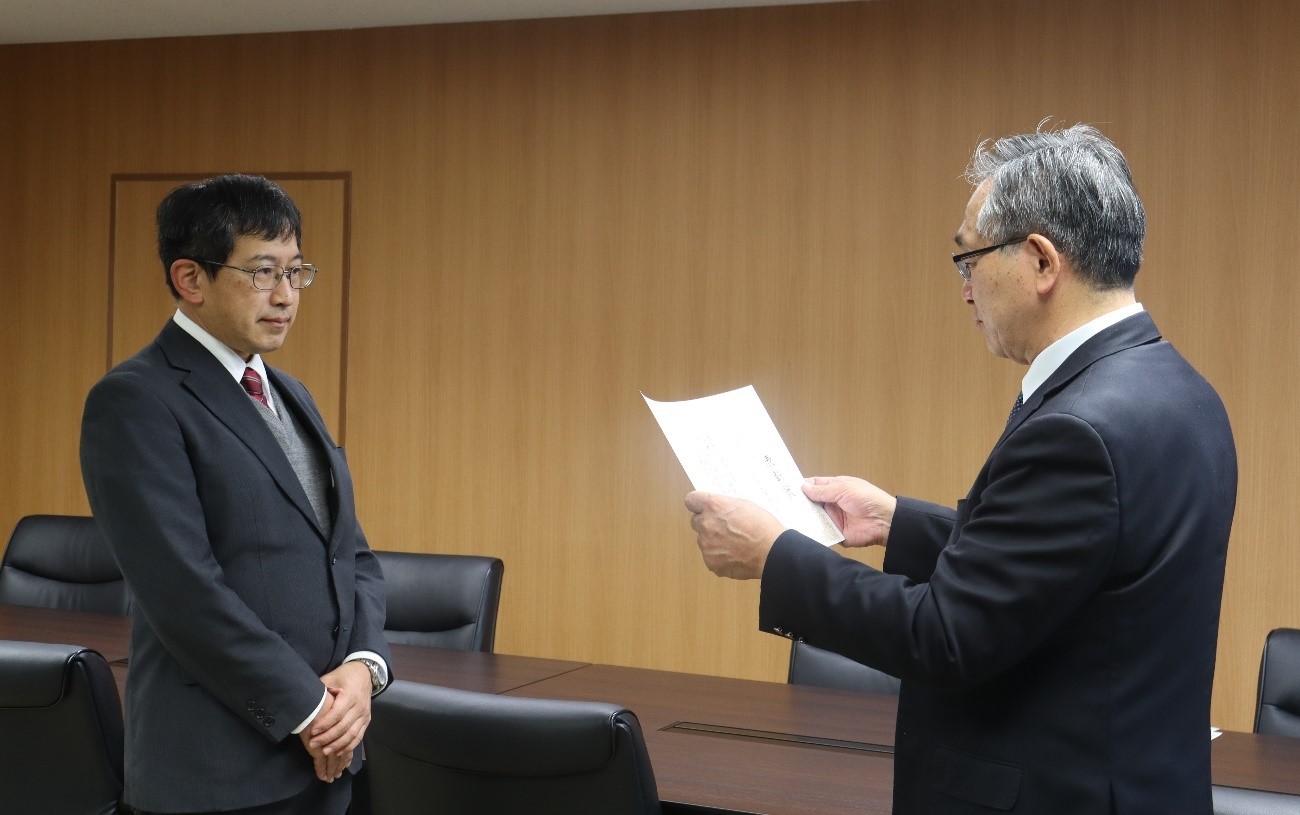 高田研究科長から松村教授へ顕彰状が手渡される様子