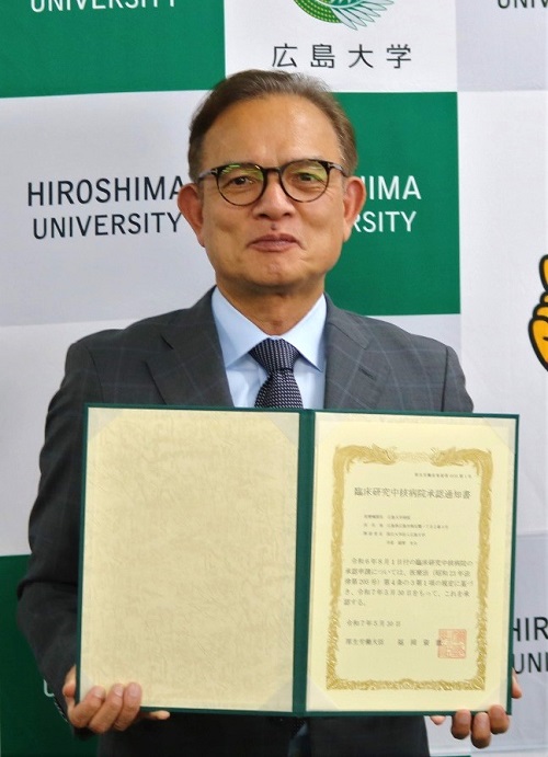 承認通知書を持つ安達伸生病院長