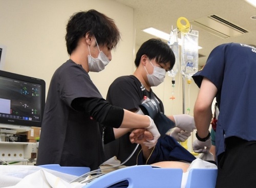 搬送された患者に心電計や血圧計を装着