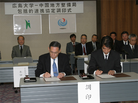 協定書に署名する、甲村中国地方整備局長（右）と牟田学長