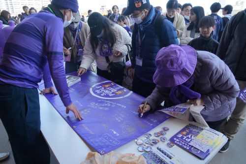 横断幕へメッセージを書き込む