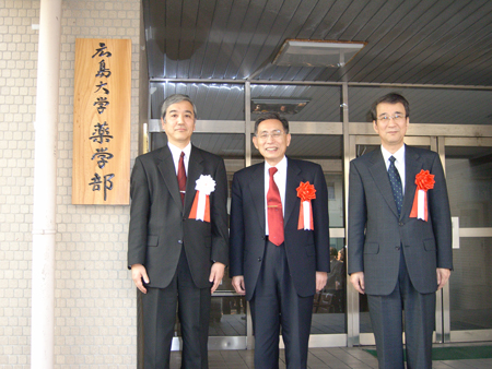 薬学部の看板前にて。牟田学長（中央）、弓削副学長（右）、太田薬学部長（左）