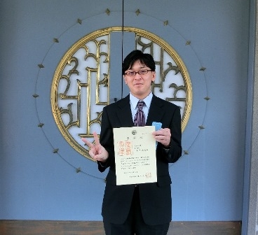 写真:理学部ピロティ前の金子さん
