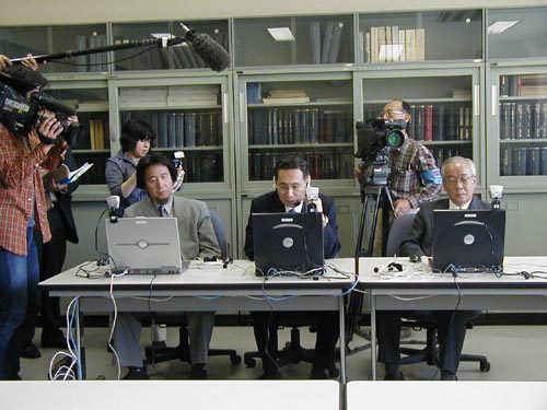 試験を前に北京研究センターとの交信を確認する牟田学長（中央）