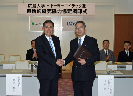 協定書を交換し握手する山本健一社長（左）と牟田泰三学長