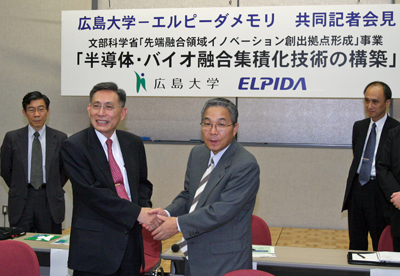 記者会見終了後、握手する牟田泰三広島大学長（左）と坂本幸雄エルピーダメモリ代表取締役社長兼ＣＥＯ