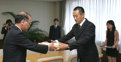 義援金を贈呈する浅原学長（左）。右は学友会会長の張紅岩さん。