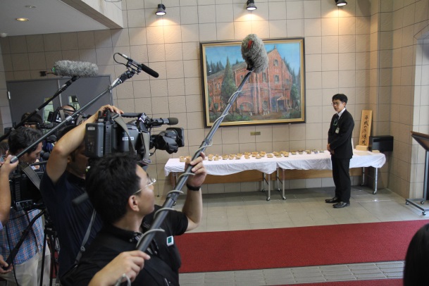 多くの報道陣を前に説明する嘉陽会長