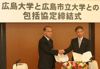 調印を終え握手を交わす広島市立大学・浅田学長（右）と広島大学・浅原学長（左）